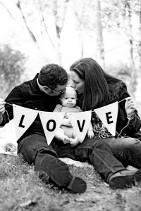 A family holding a banner spelling LOVE