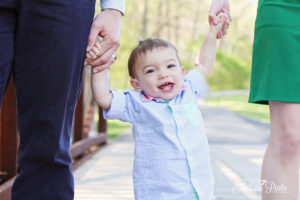 Toddler walking with parents 