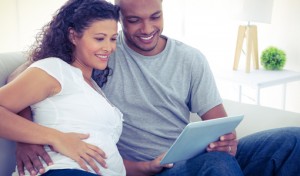pregnant couple with tablet