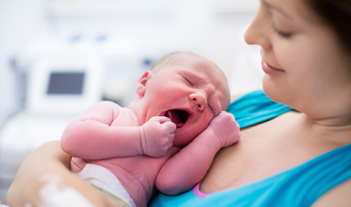 Mom Holding Newborn After Cesarean