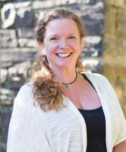 Red, curly haired caucasian woman in a white sweater