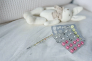 Thermometer and medicine in a crib 