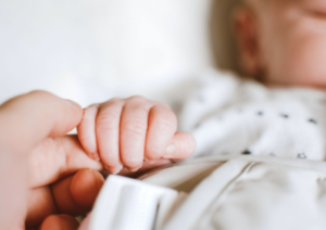 Infant holding parents finger