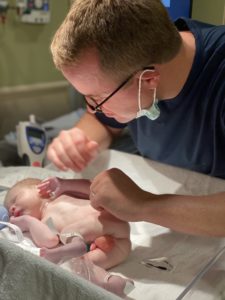 Father examines newborn son naked in hospital isolate