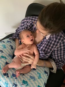 Mother in plaid shirt exploring her newborn's face