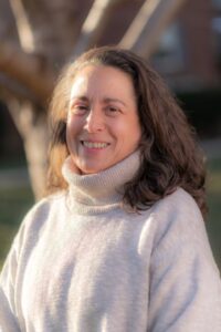 Brunette woman in a white turtle neck outside