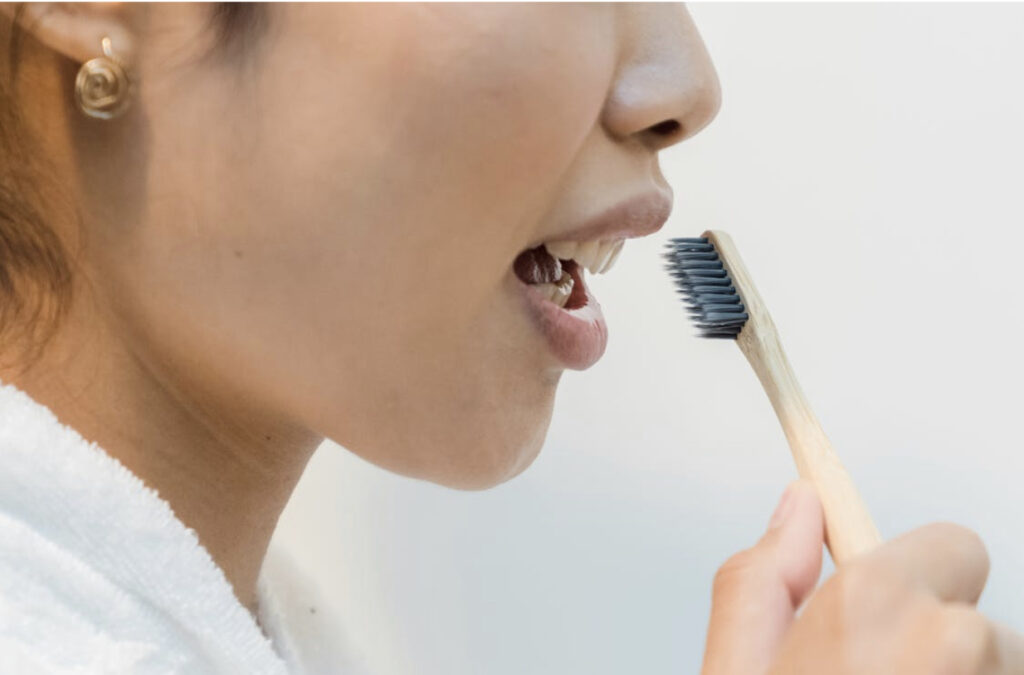 Asian or an brushing her teeth 