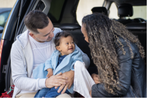 A mixed family playign wiht a toddler int eh truck of a SUV