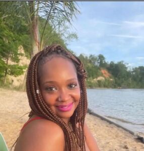 Caribbean woman with braids sitting by the water
