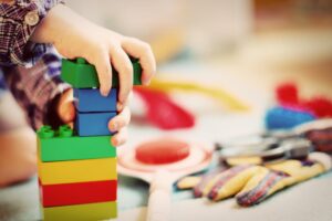 child playing with blocks demonstrating gross motor milestones