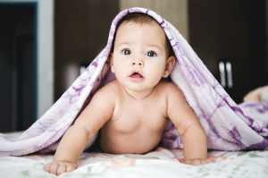 young baby on belly under a purple blanket