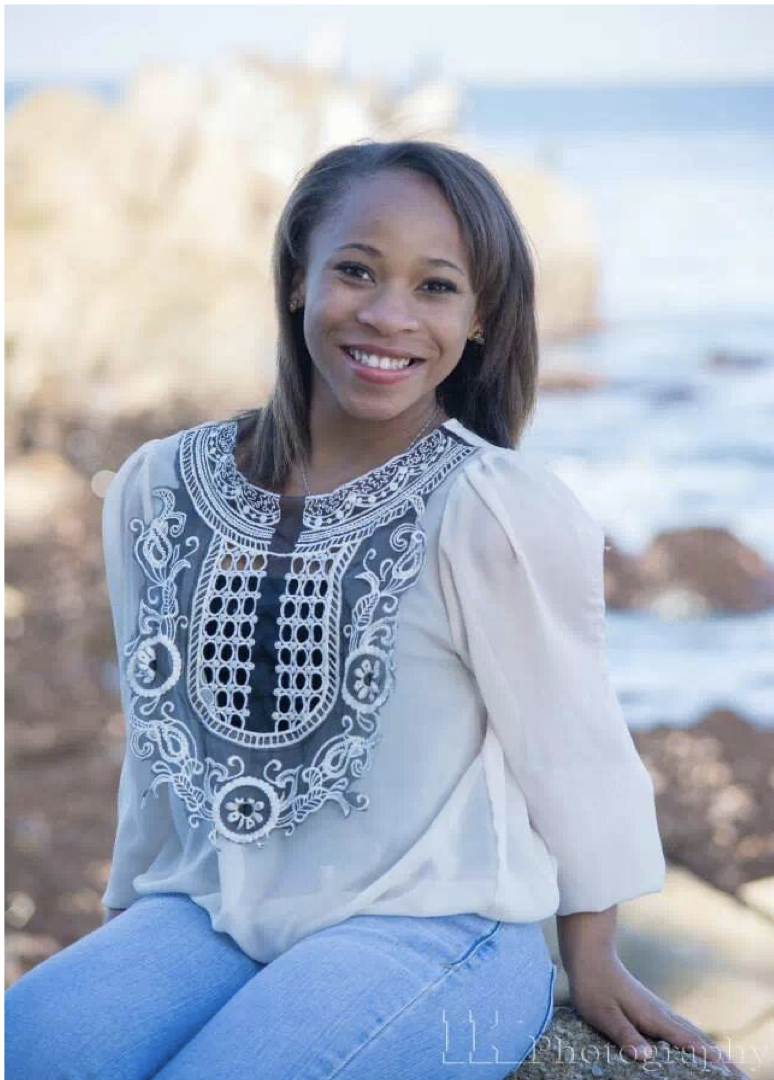 African woman with straight hair in a white shirt with blue embroidery