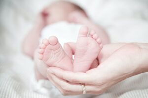 Close up of newborn toes in a parents hand.