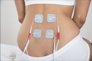 4 white tens pads on a woman's lower back