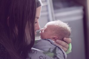 brunette mother nose to nose with a blonde newborn