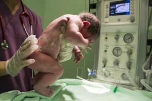 Image of a newborn baby being examined in the hospital