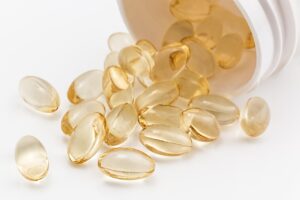 clear yellow capsules coming out of a white bottle 